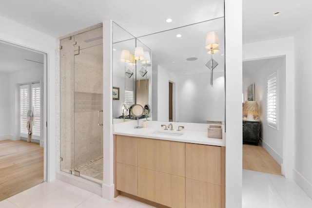 ensuite bathroom featuring recessed lighting, vanity, a shower stall, tile patterned floors, and ensuite bath