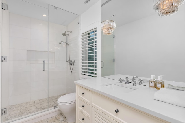 full bath featuring a stall shower, vanity, toilet, and an inviting chandelier