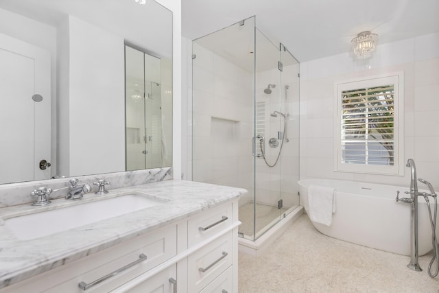 bathroom featuring a stall shower, a freestanding bath, and vanity