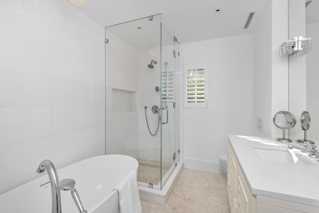 full bathroom featuring visible vents, a freestanding bath, a shower stall, vanity, and speckled floor