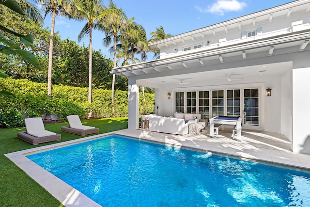 view of swimming pool with a fenced in pool, a patio, a lawn, ceiling fan, and an outdoor living space