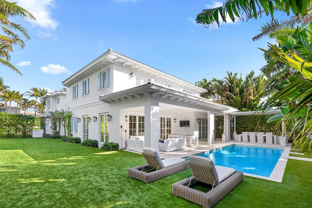 back of house with a patio, an outdoor living space, a yard, an outdoor pool, and stucco siding