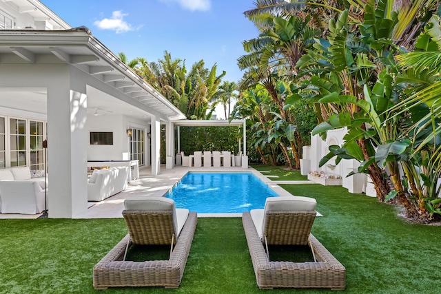 outdoor pool with a patio area, an outdoor hangout area, a ceiling fan, and a yard