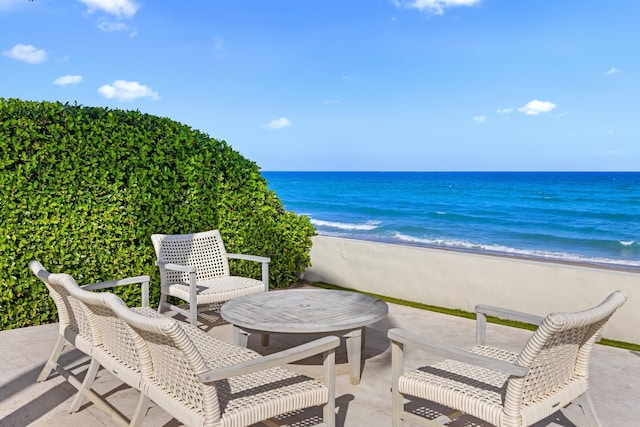 view of patio / terrace with a water view and a beach view