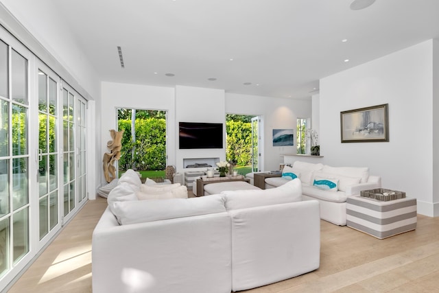 living area featuring a healthy amount of sunlight, light wood-style flooring, visible vents, and recessed lighting