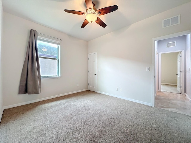 spare room with baseboards, visible vents, and light colored carpet