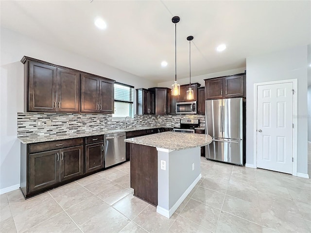 kitchen featuring pendant lighting, decorative backsplash, appliances with stainless steel finishes, a kitchen island, and dark brown cabinetry