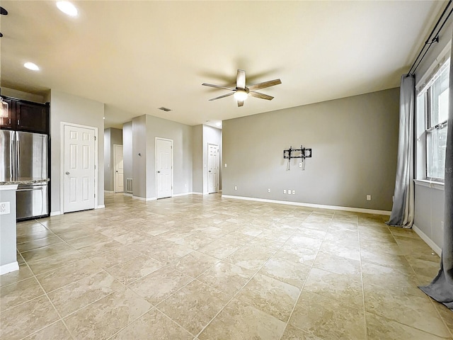 unfurnished living room featuring ceiling fan, visible vents, and baseboards