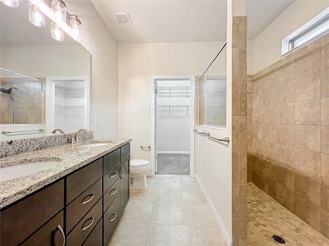 full bathroom featuring a walk in closet, a sink, and a walk in shower