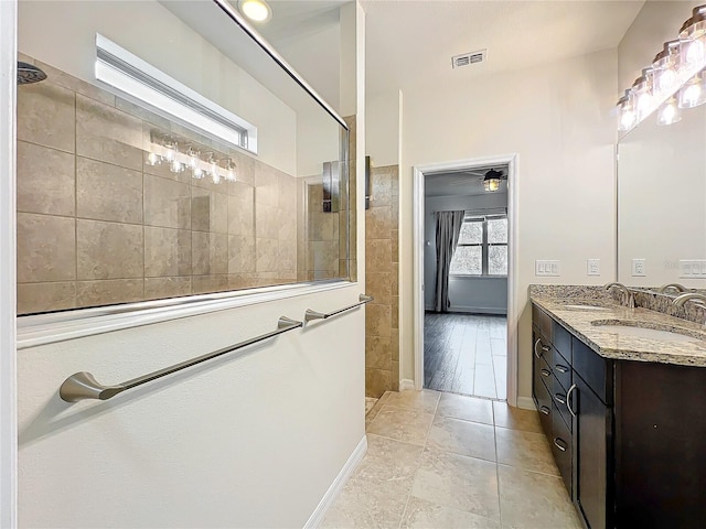 full bath featuring double vanity, visible vents, a sink, and a walk in shower