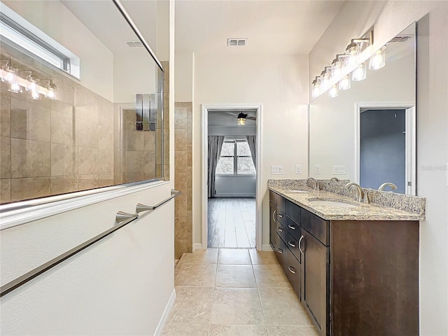 bathroom with double vanity, a sink, visible vents, and baseboards