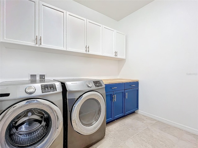 laundry area featuring cabinet space, baseboards, and washing machine and clothes dryer