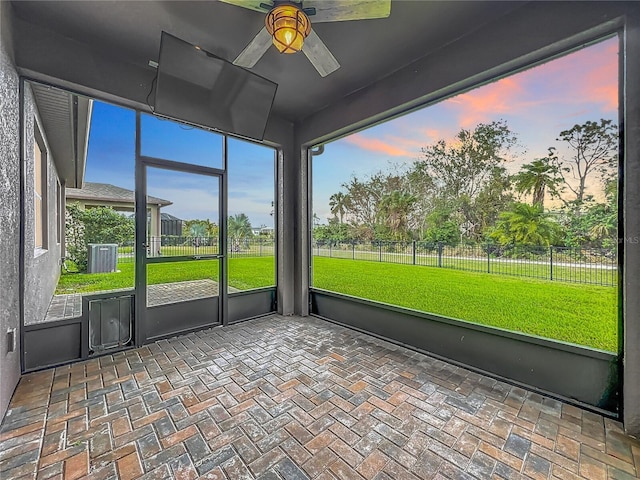 unfurnished sunroom featuring a ceiling fan