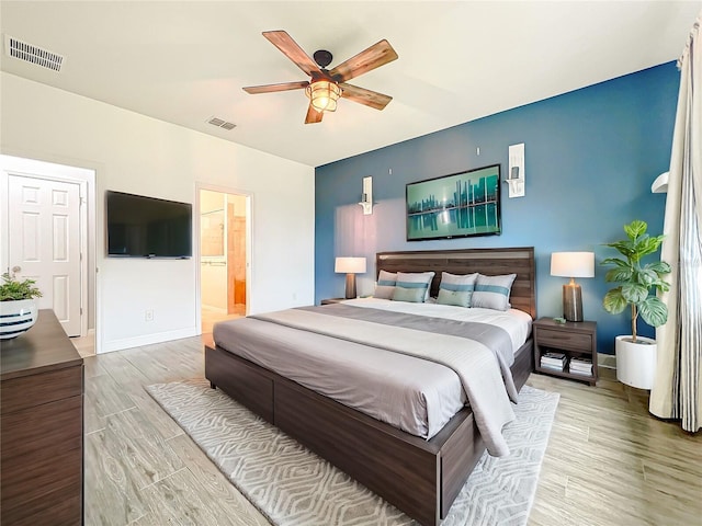 bedroom featuring light wood-type flooring, visible vents, ceiling fan, and baseboards