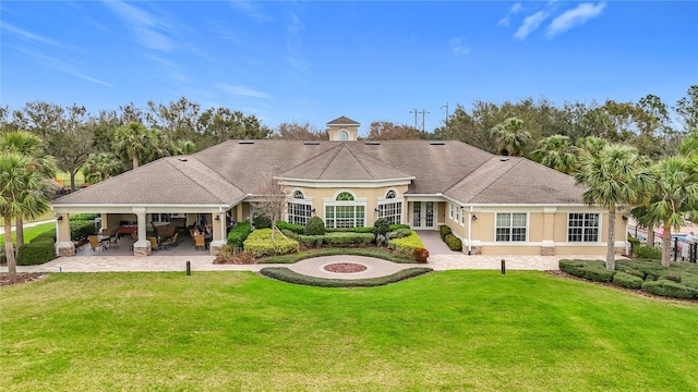 back of property featuring a patio, an outdoor fire pit, a lawn, and stucco siding