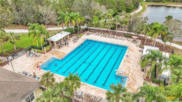 pool featuring a water view, fence, and a patio