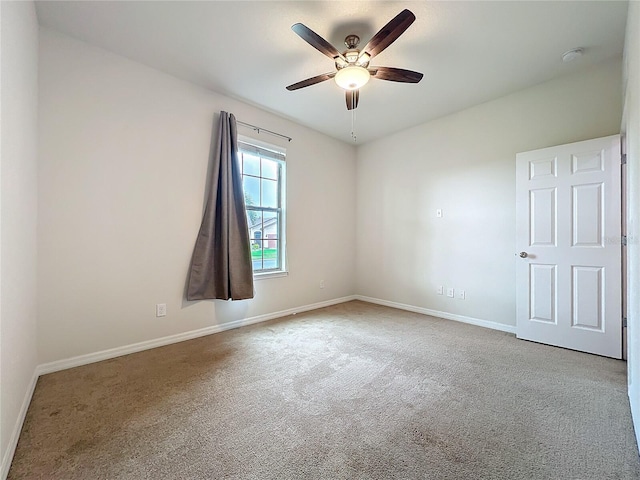 empty room with baseboards, ceiling fan, and light colored carpet