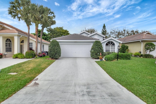 view of front facade featuring a garage, a tile roof, concrete driveway, stucco siding, and a front lawn