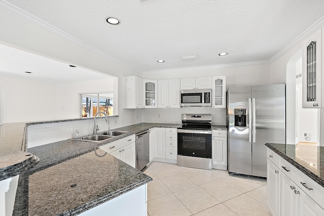 kitchen featuring light tile patterned floors, appliances with stainless steel finishes, glass insert cabinets, ornamental molding, and a sink