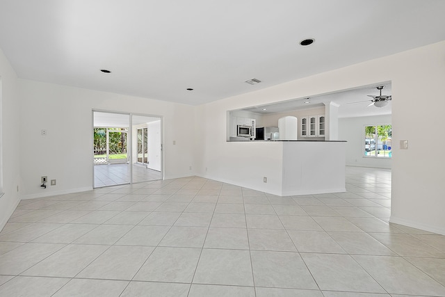 unfurnished room featuring light tile patterned floors, a ceiling fan, visible vents, and baseboards