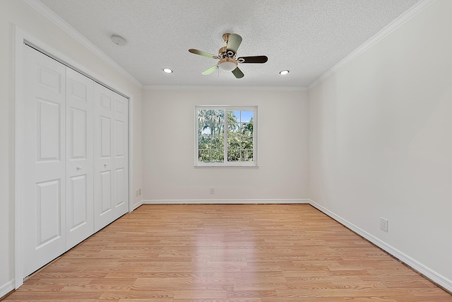 unfurnished bedroom with light wood-type flooring, a closet, crown molding, and a textured ceiling