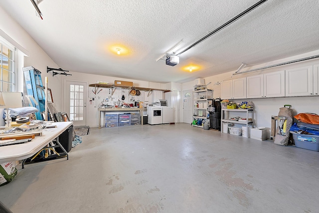 garage featuring a workshop area, washing machine and dryer, and a garage door opener