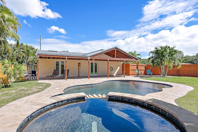 view of swimming pool featuring a lawn, a fenced backyard, french doors, a patio area, and a pool with connected hot tub