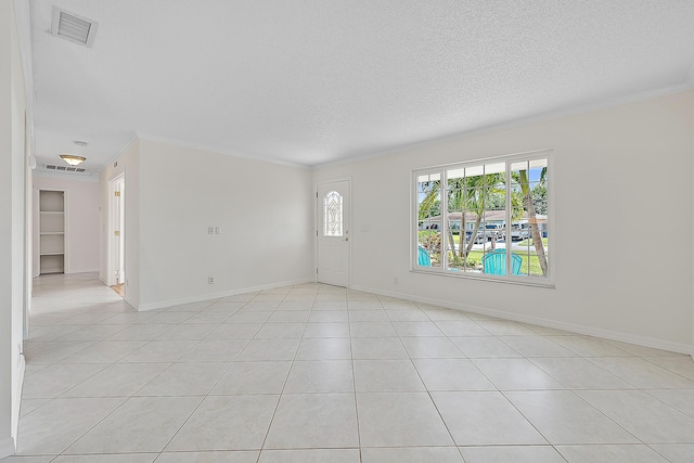 spare room with visible vents, crown molding, a textured ceiling, and baseboards