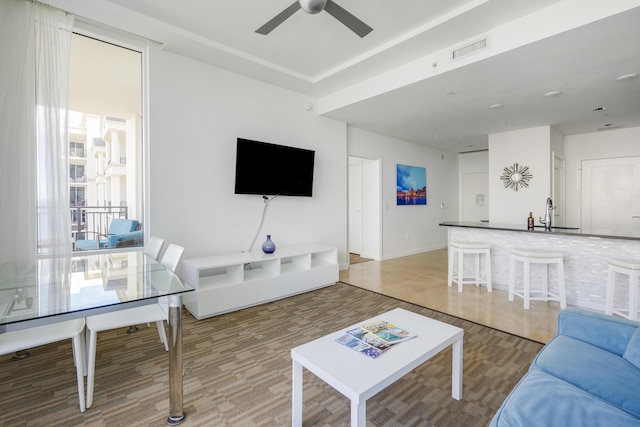 living area featuring visible vents and a ceiling fan