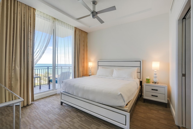 bedroom with a water view, access to exterior, and ceiling fan