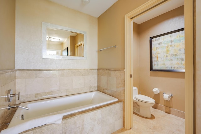 bathroom with toilet, a garden tub, tile patterned flooring, and baseboards