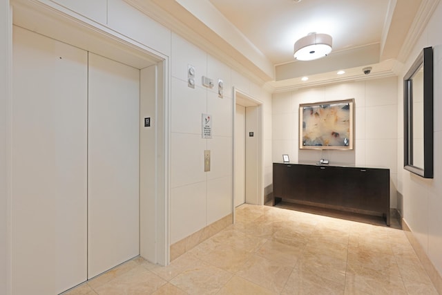 hallway with ornamental molding and elevator