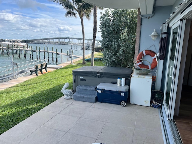 view of patio with a dock, a water view, and a hot tub