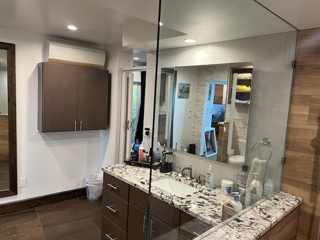 bathroom featuring recessed lighting, decorative backsplash, a wall mounted AC, vanity, and baseboards