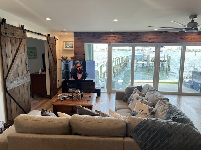 living area featuring a healthy amount of sunlight, a barn door, ceiling fan, and recessed lighting