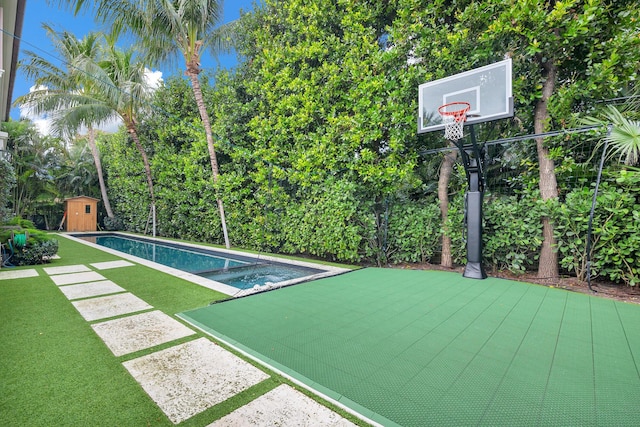 view of pool with an outbuilding, a pool with connected hot tub, a lawn, and a storage shed