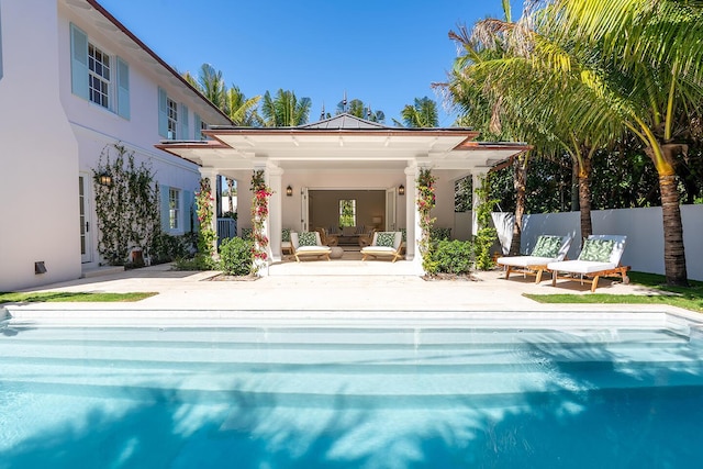 back of property with a fenced in pool, a patio area, fence, and stucco siding