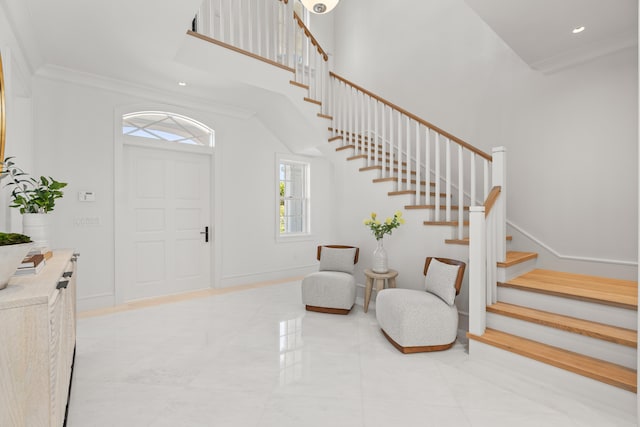 entryway with baseboards, stairway, ornamental molding, a high ceiling, and recessed lighting