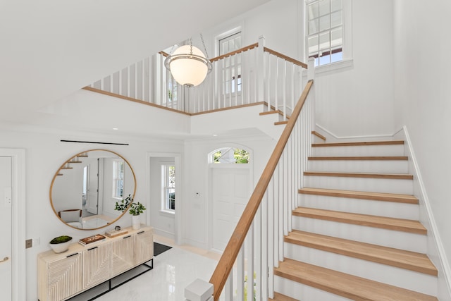 interior space featuring stairway and a towering ceiling