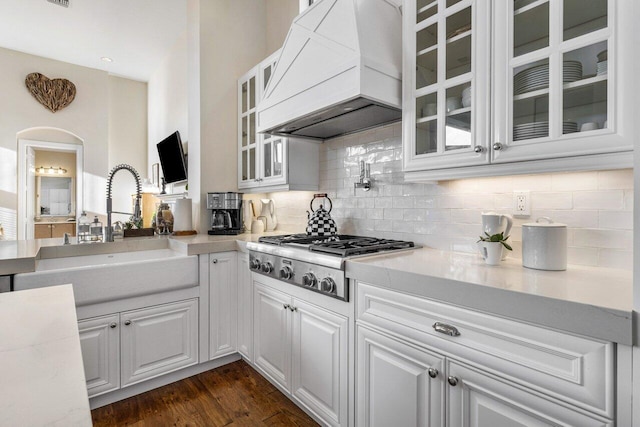 kitchen with custom range hood, light countertops, a sink, and stainless steel gas stovetop