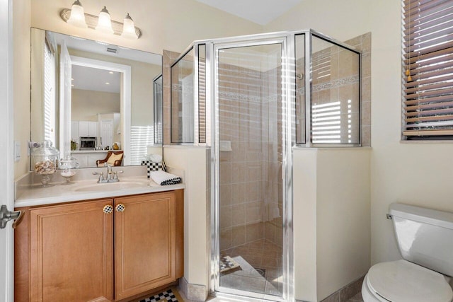 bathroom featuring a stall shower, vanity, and toilet