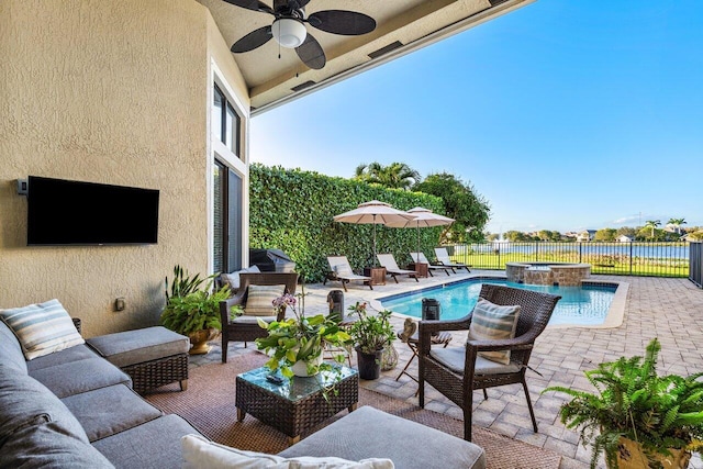 exterior space with a patio, ceiling fan, an outdoor hangout area, fence, and a pool with connected hot tub