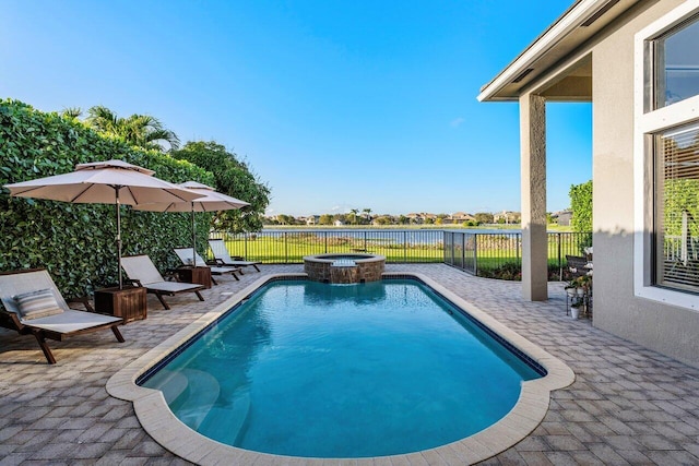 view of swimming pool featuring a water view, a patio area, a fenced backyard, and a pool with connected hot tub