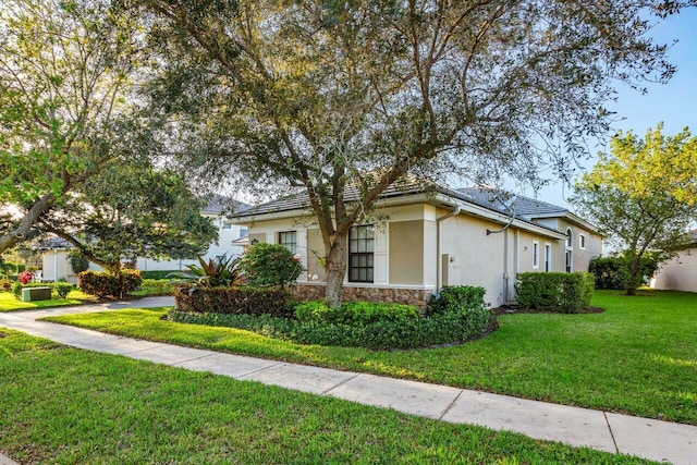 view of front of home featuring stone siding, a front lawn, and stucco siding