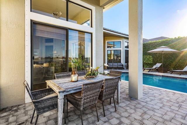 view of patio with outdoor dining area and an outdoor pool