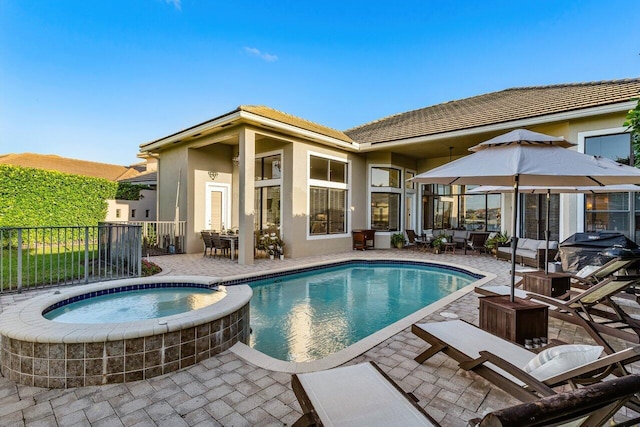 view of pool featuring grilling area, a patio area, fence, and a pool with connected hot tub