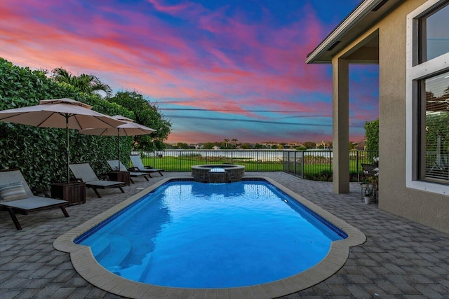 view of swimming pool featuring a pool with connected hot tub, a fenced backyard, and a patio