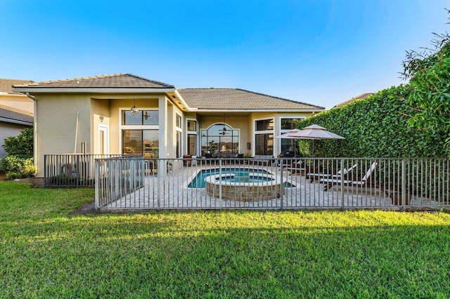 back of house featuring a fenced in pool, a patio area, a lawn, and stucco siding