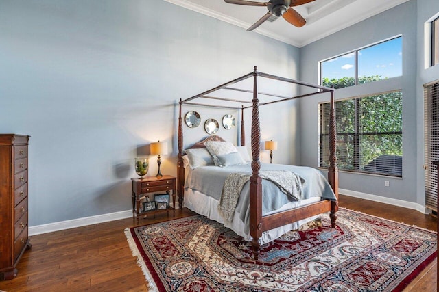 bedroom featuring multiple windows, crown molding, baseboards, and wood finished floors