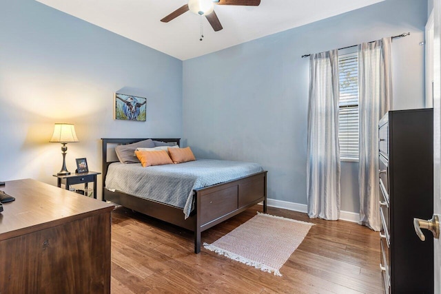 bedroom featuring ceiling fan, baseboards, and wood finished floors